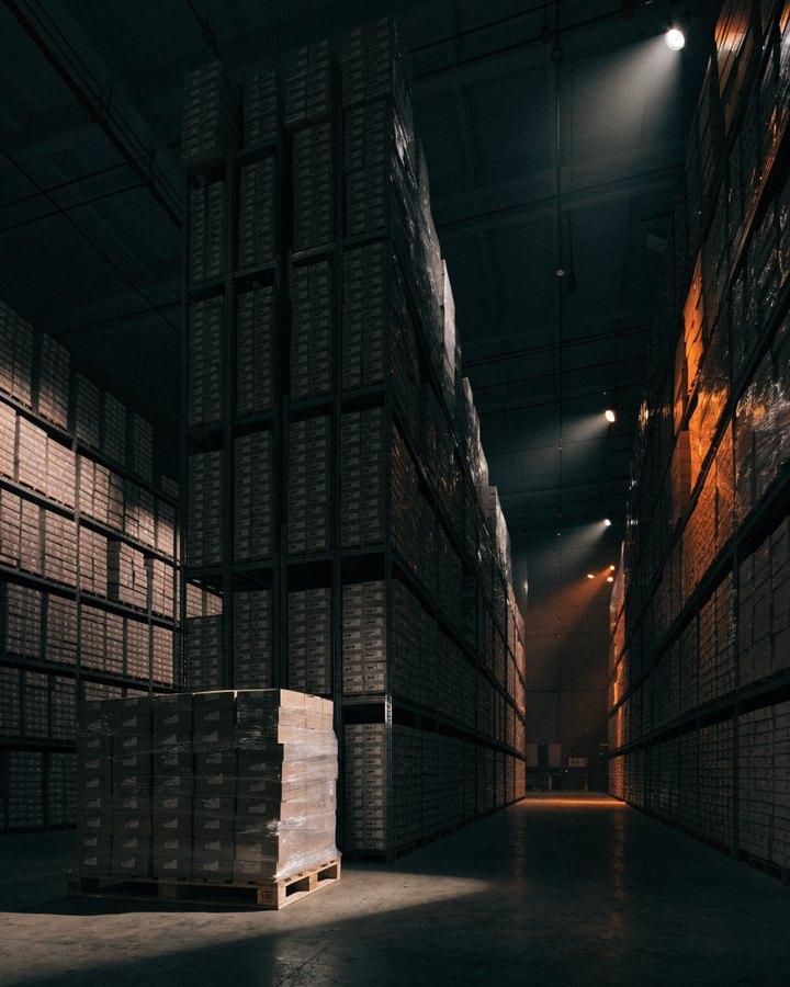 Nave del almacén con filas de estanterías y palés de cajas
